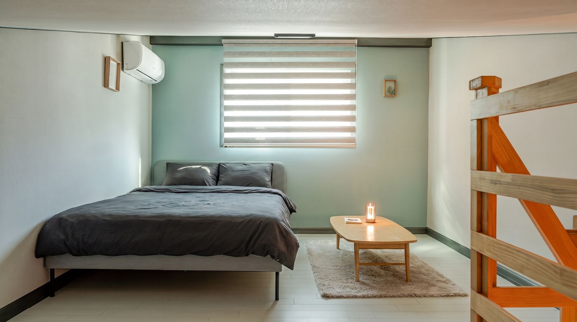 Ein Schlafzimmer mit einem Bett, einem Nachttisch mit Lampe, einem Fenster mit Jalousien und einer hölzernen Bank.