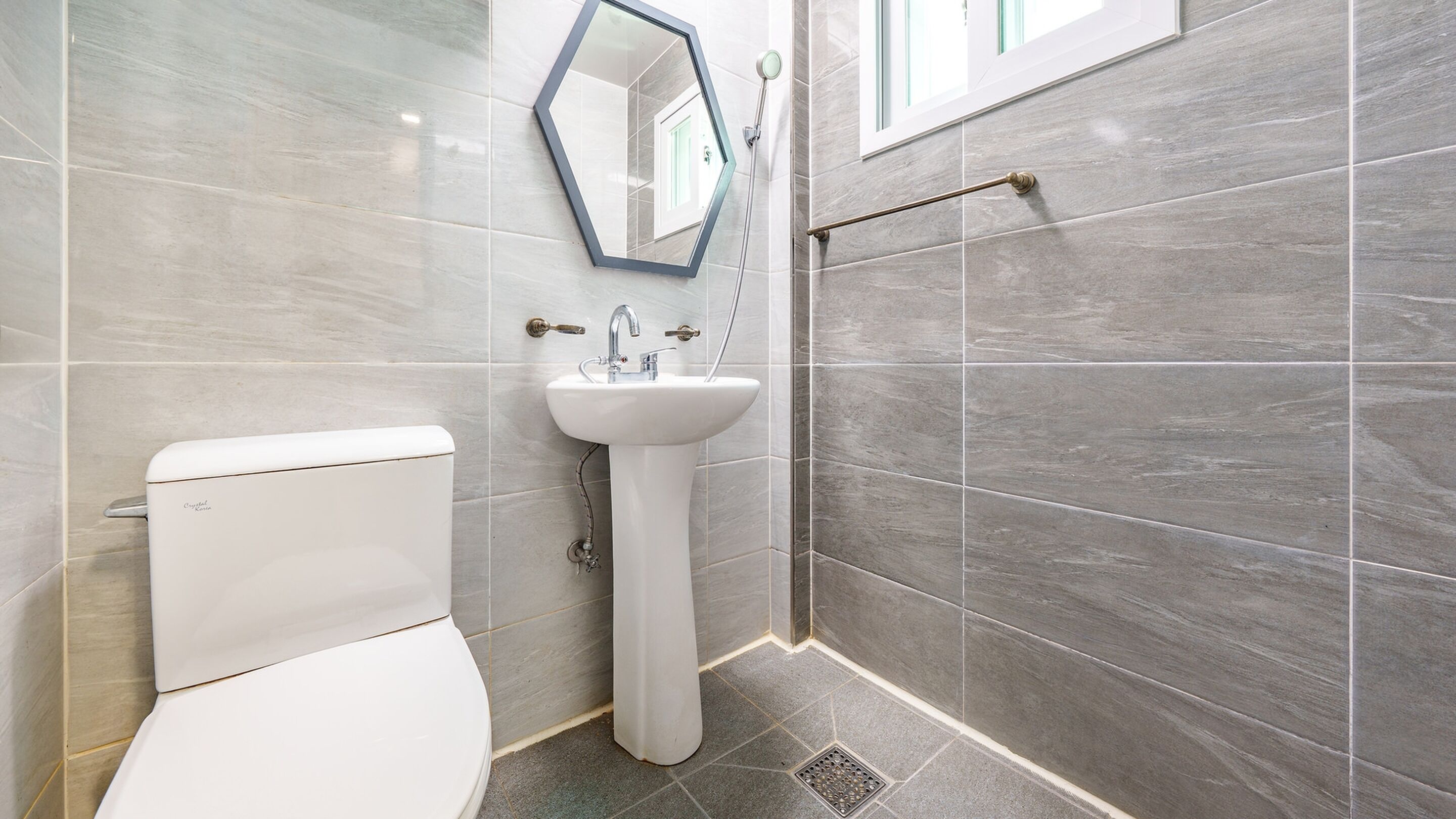 Une salle de bain moderne équipée de toilettes, d’un lavabo et d’une douche.