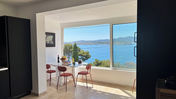 A modern kitchen with a large window overlooking a scenic view of the sea and hills. - Breathtaking Mediterranean Views. Walk to Portissol Beach & Port. WiFi & AC. (Sanary Sur Mer)