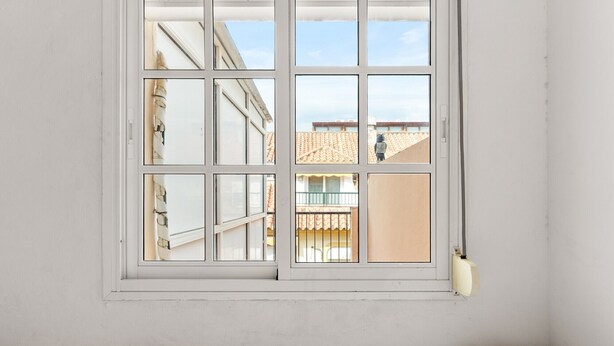 A room with a large window, a bed with patterned bedding, and a wall-mounted light fixture. - Apartment 'Med Stor Terass' with Mountain View, Wi-Fi and Air Conditioning (Fuengirola)