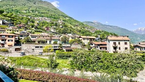Un village perché sur une colline, avec des bâtiments traditionnels, un sentier pavé de pierres et une vue sur les montagnes.
