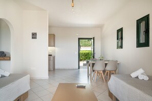 Une chambre d’hôtel avec un lit, un bureau, une chaise et une vue sur un jardin.