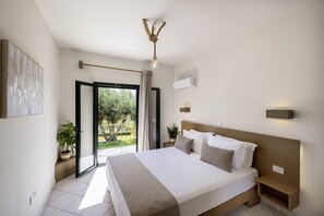 Une chambre moderne avec un grand lit, un luminaire au plafond, une plante en pot et une vue à travers une porte vitrée.