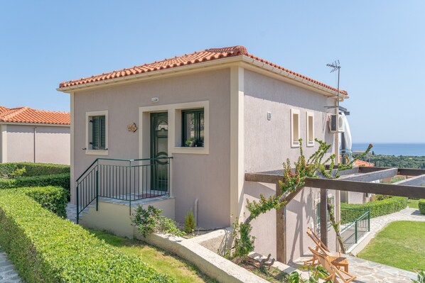 Un petit bâtiment d’un seul étage, doté d’un toit en tuiles, d’un balcon avec une balustrade en métal et offrant une vue sur la mer.