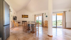 A spacious kitchen with a dining area, a refrigerator, and a large window with a view. - Villa 'Harmònia' with sea view, Wi-Fi and air conditioning (Villasimius)