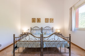 A room with a four-poster bed, a window with curtains, and three framed pictures on the wall. - Room 'Campus' with Sea View, Wi-Fi and Air Conditioning (Villasimius)