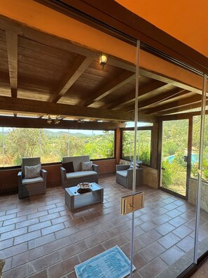Una habitación amplia con techo alto, ventanas grandes y vistas a zonas verdes.