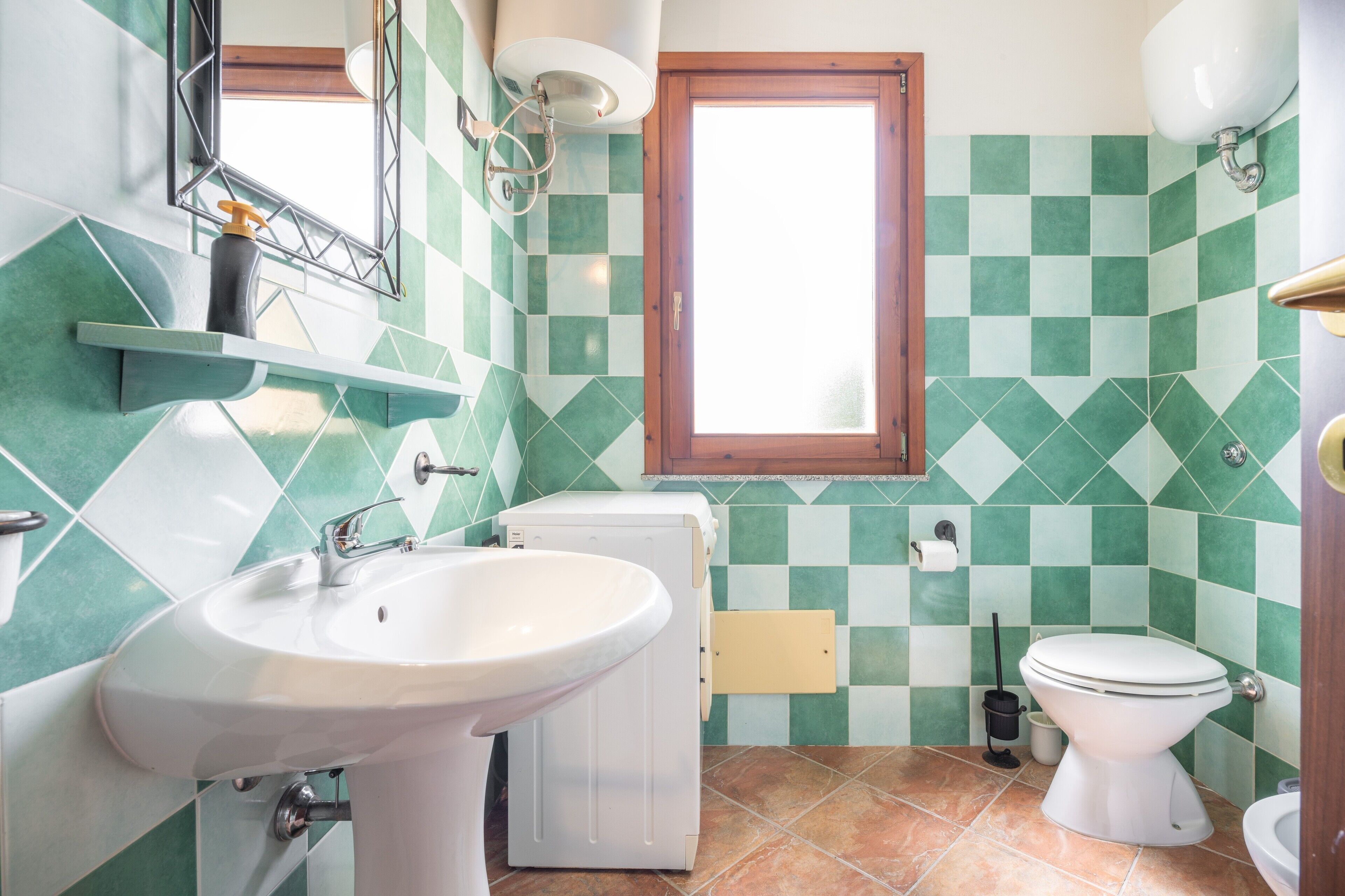 A bathroom with a sink, toilet, and washing machine.