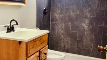 Habitación triple básica | Baño | Ducha, secador de pelo, toallas y jabón