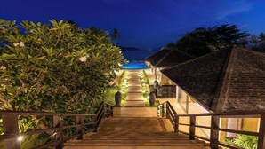 A wooden staircase leading to a pool area with a view of the ocean at dusk. - Villa Sai Tai – A Private Haven on the Edge of Paradise (Thong Krut)