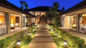 A hotel with a central staircase leading to a covered area, surrounded by well-lit pathways and greenery. - Villa Sai Tai – A Private Haven on the Edge of Paradise (Thong Krut)