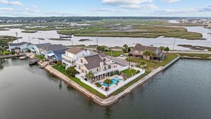A waterfront property with multiple houses, a dock, and a swimming pool.