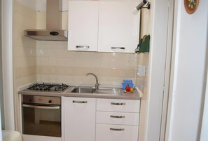 Réfrigérateur, un four, surface de cuisson, vaisselle et ustensiles