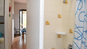 A bathroom with a shower, toilet, and sink.