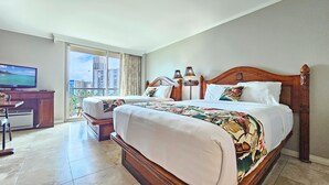A hotel room with a large bed, a desk with a television, and a view of tall buildings.