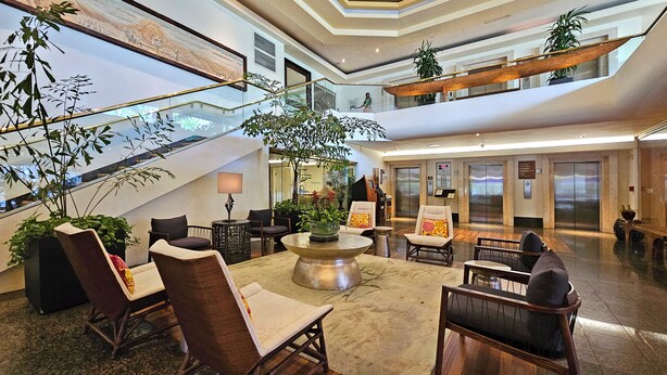 A spacious lobby with a central seating area, a staircase, and multiple levels.