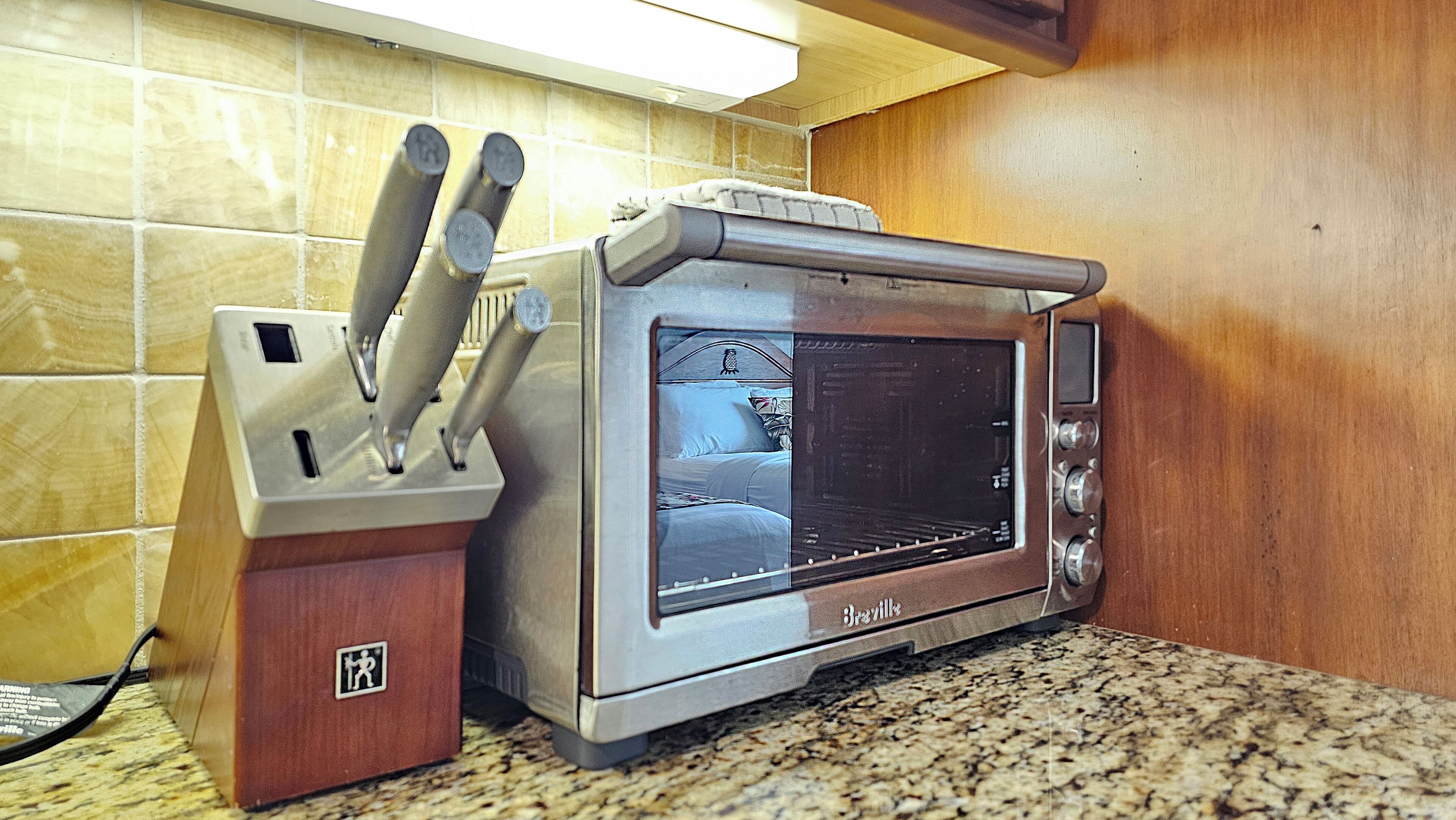 Une cuisine équipée d’un four grille-pain et d’un bloc à couteaux.