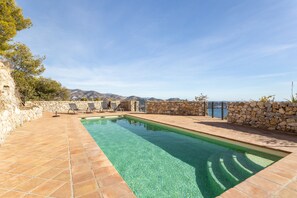 A rectangular swimming pool with clear water, surrounded by stone walls and a stone fence, with a view of mountains in the background. - Villa 'Five Star  with Heavenly Views' with Sea View, Wi-Fi and Air Conditioning (La Herradura)