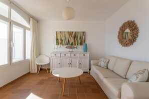 A living room with a white sofa, a round coffee table, a white cabinet, a painting on the wall, and a decorative mirror. - Villa 'Five Star  with Heavenly Views' with Sea View, Wi-Fi and Air Conditioning (La Herradura)