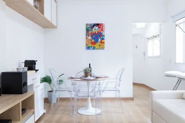 Uma cozinha moderna com uma mesa de jantar, cadeiras e uma máquina de café.
