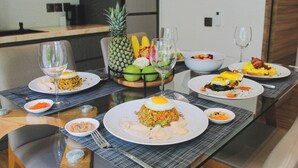 A dining table with various dishes, glasses, and a pineapple centerpiece.