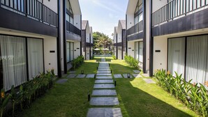 A modern hotel with a central courtyard, featuring a stone pathway leading to a seating area.