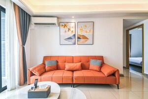 A modern living room with a sofa, a remote control, and a tissue box on a table.