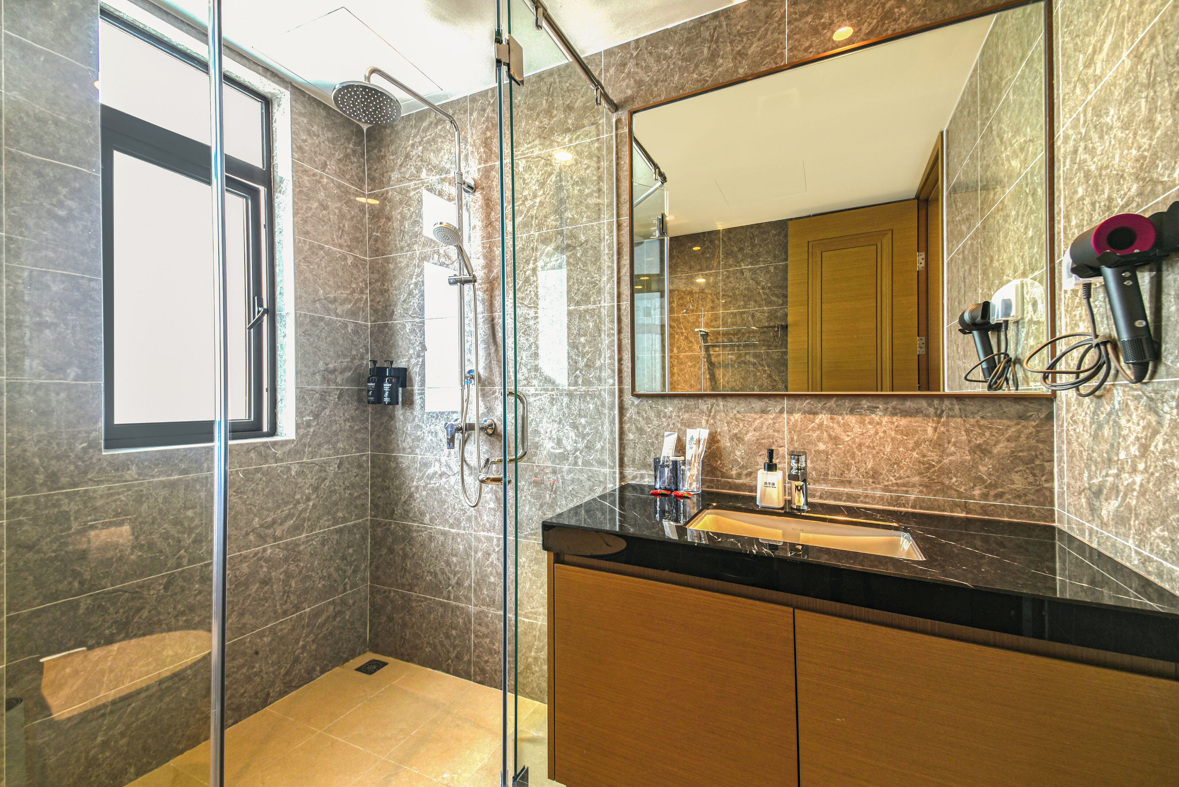 Une salle de bain moderne avec une douche à parois de verre, un meuble-lavabo et un grand miroir.