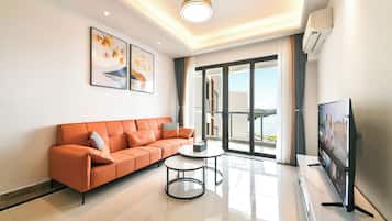 A modern living room with a sofa, a coffee table, and a flat-screen TV.