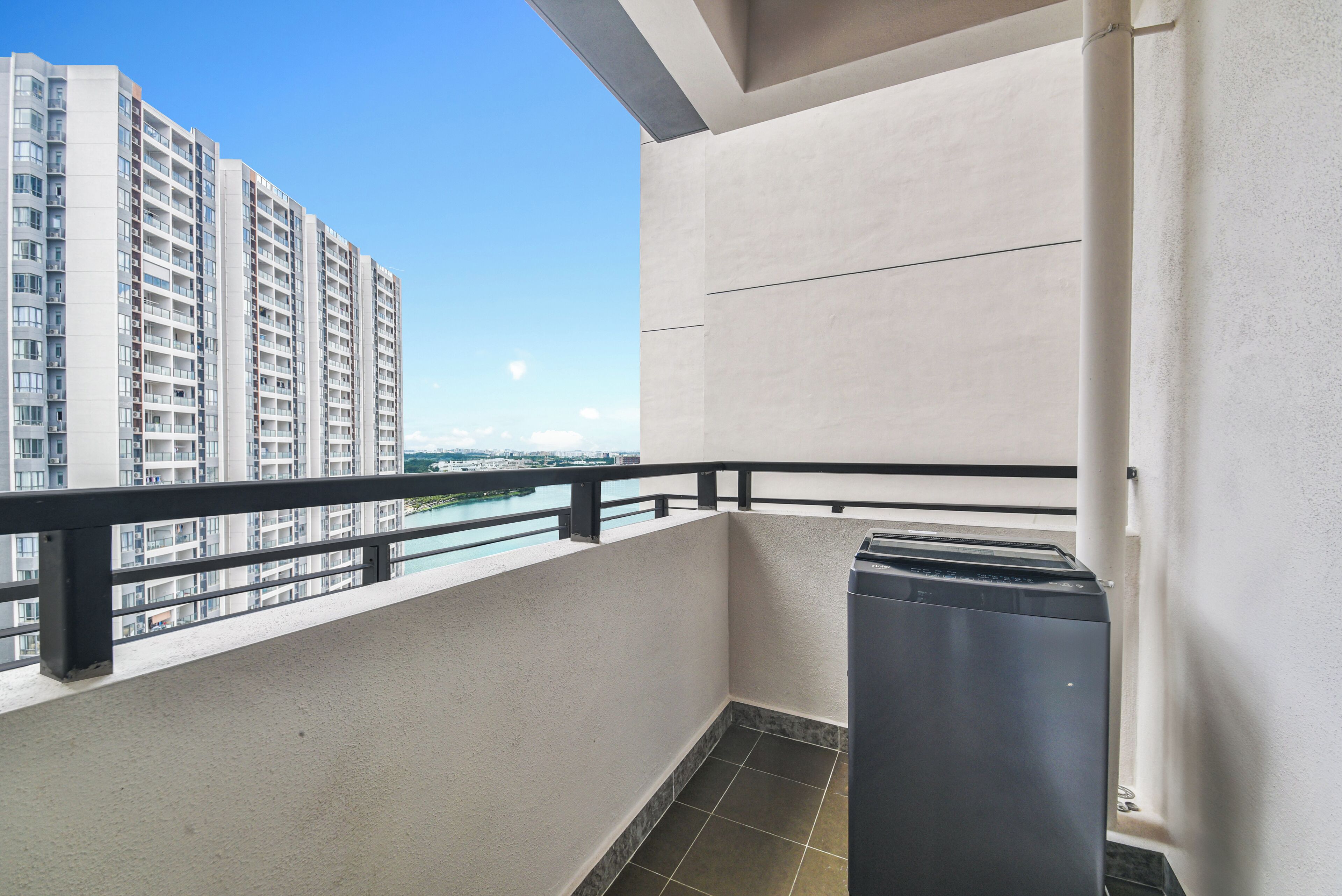 A balcony with a view of high-rise buildings and a clear sky.