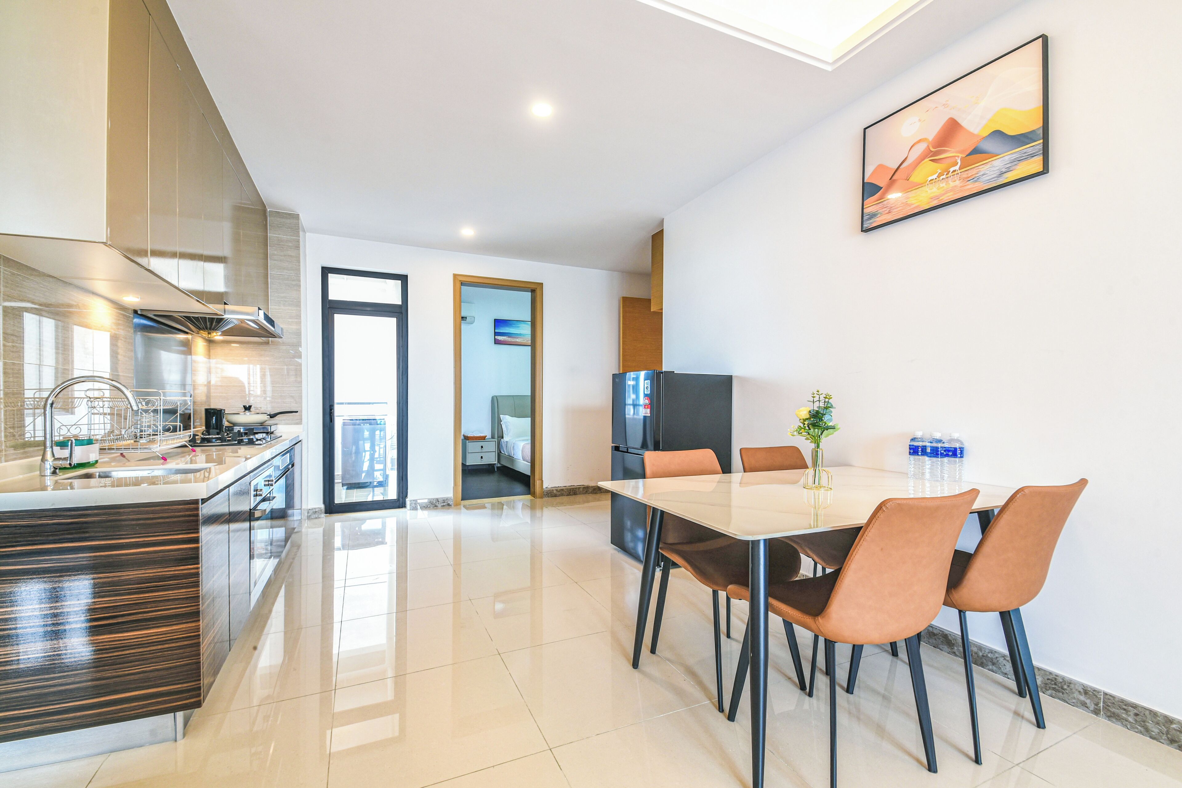 Een moderne keuken met een centraal eiland, een eethoek met tafel en stoelen, en een groot raam dat voor natuurlijk licht zorgt.