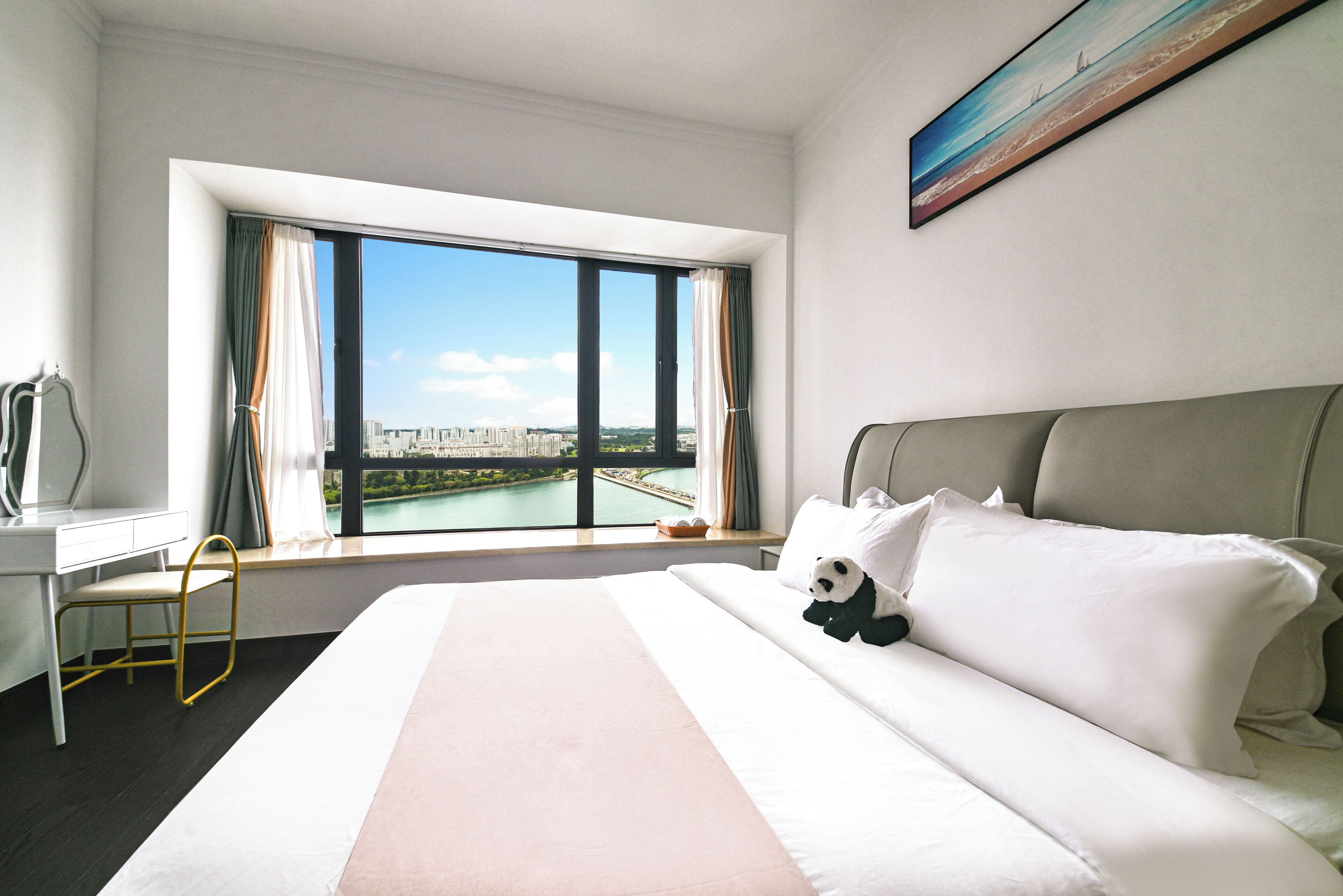 A hotel room with a large bed, a desk, and a window with a city view.