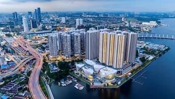 A high-rise residential building complex with multiple floors, adjacent to a body of water, featuring a marina with boats.