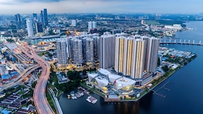 A high-rise residential building complex with multiple floors, adjacent to a body of water, featuring a marina with boats.