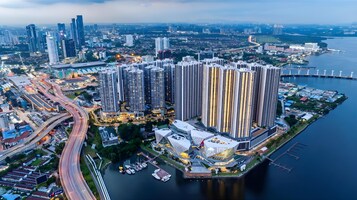 A high-rise residential building complex with multiple floors, adjacent to a body of water, featuring a marina with boats.