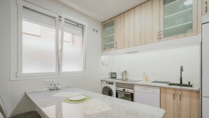 Cucina con piano di lavoro in granito, mobili in legno, forno a microonde, lavello e lavastoviglie.