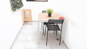 A small dining area with a white table, black chairs, a potted plant, and a red bowl. - Casa 'Discover the Sea' Vacation Home with Private Terrace and Wi-Fi (La Garita)