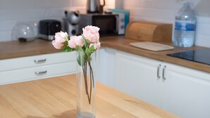 A kitchen with a wooden countertop, a clear vase with flowers, a kettle, and a water bottle. - Casa 'Discover the Sea' Vacation Home with Private Terrace and Wi-Fi (La Garita)