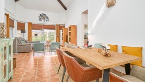 Un'ampia zona giorno con tavolo da pranzo in legno, comodi posti a sedere e vista sull'esterno.