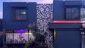 A modern building with a large, intricate black and white mural on the facade.