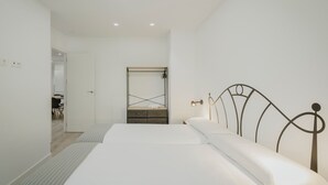 Une chambre à coucher avec un lit, une table de chevet et un miroir.