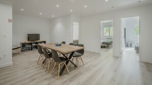 Un espace de vie moderne comprenant un coin repas, un téléviseur et une cuisine.