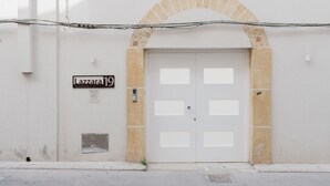 A building entrance with a double door, a sign above the door, and a small window to the left.