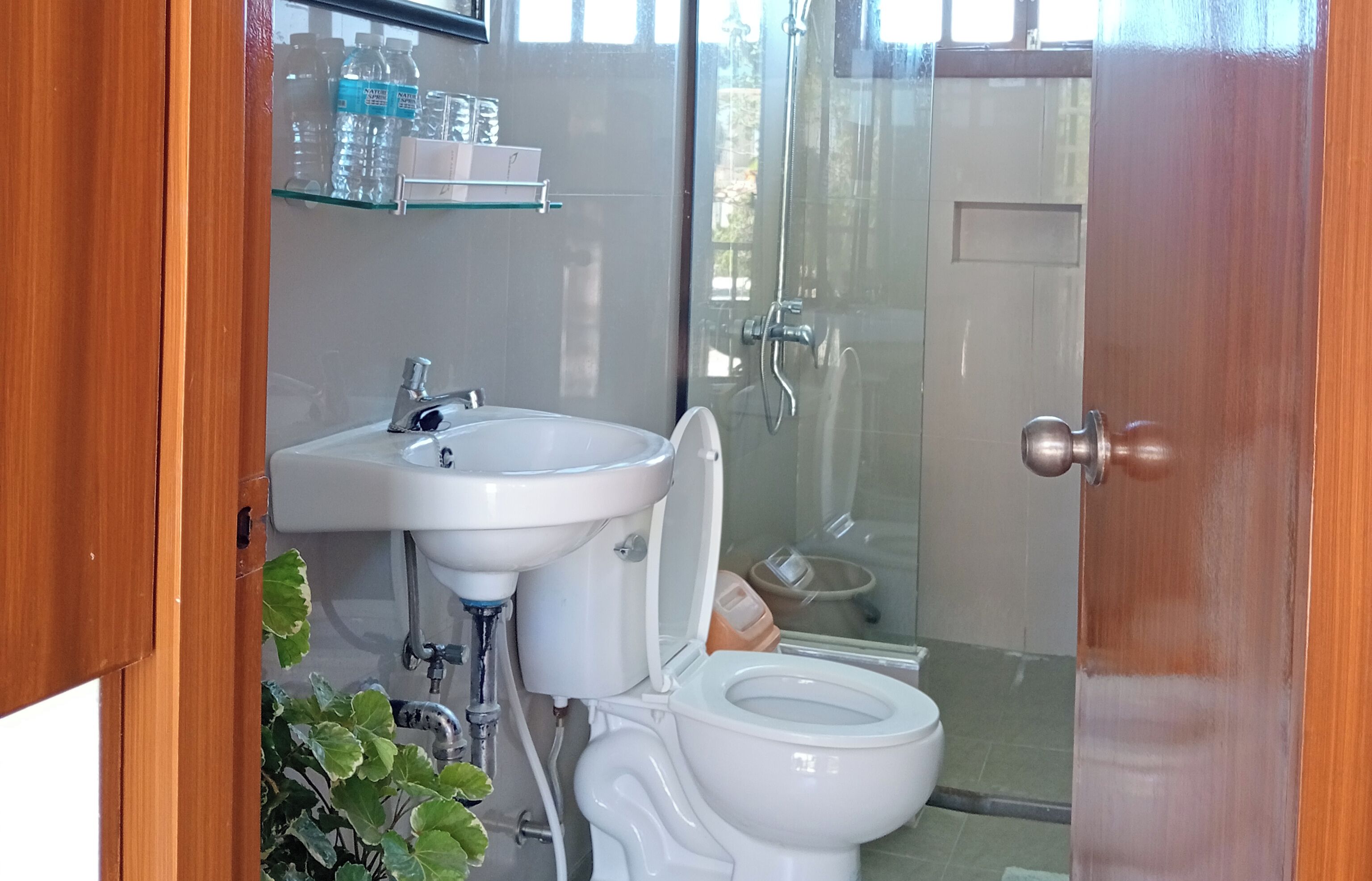 Un baño con lavamanos, inodoro y zona de ducha.