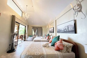 Une chambre spacieuse avec deux lits, de grandes fenêtres et une vue sur l’extérieur.