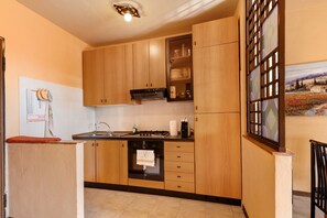 Una cocina con armarios de madera, una estufa y un lavaplatos.