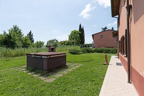 Ein Garten mit einem Holler Schuppen, einem Weg und einem Gebäude mit roter Fassade.