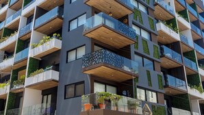 Un hotel de varios pisos con balcones, un restaurante a nivel de calle y un diseño arquitectónico moderno.