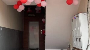 Ein Flur mit einer Tür zu einem Raum, dekoriert mit roten und weißen Luftballons.
