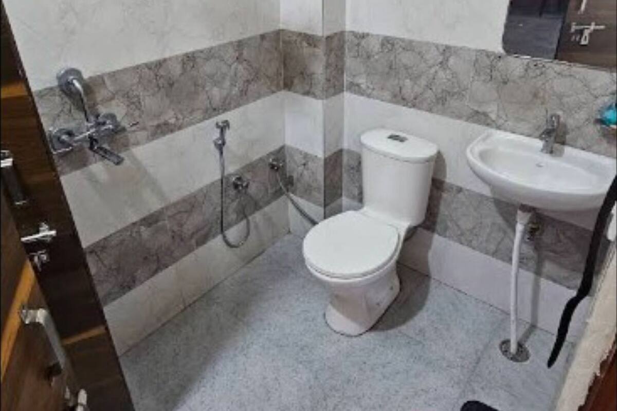 Une salle de bain équipée de toilettes, d’un bidet et d’un lavabo.